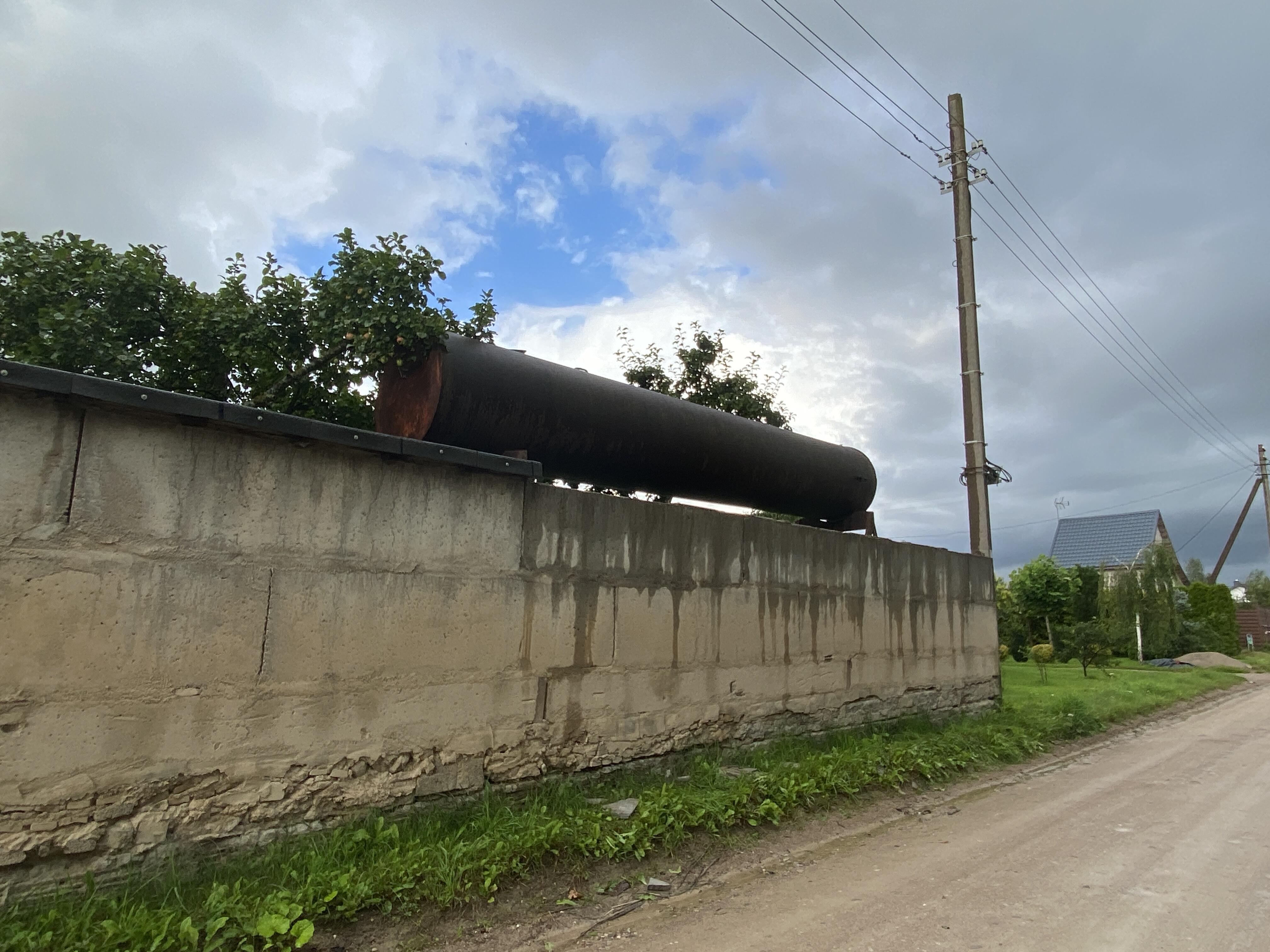 Atstumai: ESO nesiryžo kreiptis į Statybų inspekciją, kad būtų nugriauta tvora, į kurią įmūryti elektros stulpai, saugumui netrukdė ir metalinis rezervuaras po elektros laidais.