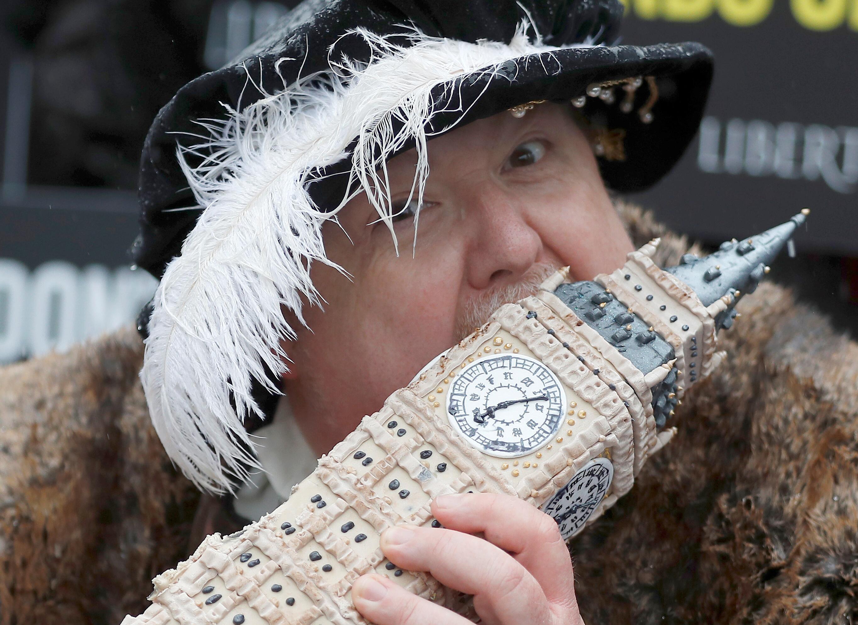 Požiūris: Didžiosios Britanijos praeityje buvo visko, tačiau net ir į baisius įvykius dalis britų linkę žvelgti su humoru. Šioje nuotraukoje Henriku VIII apsirengęs aktorius valgo saldų simbolį – Big Beną primenantį užkandį