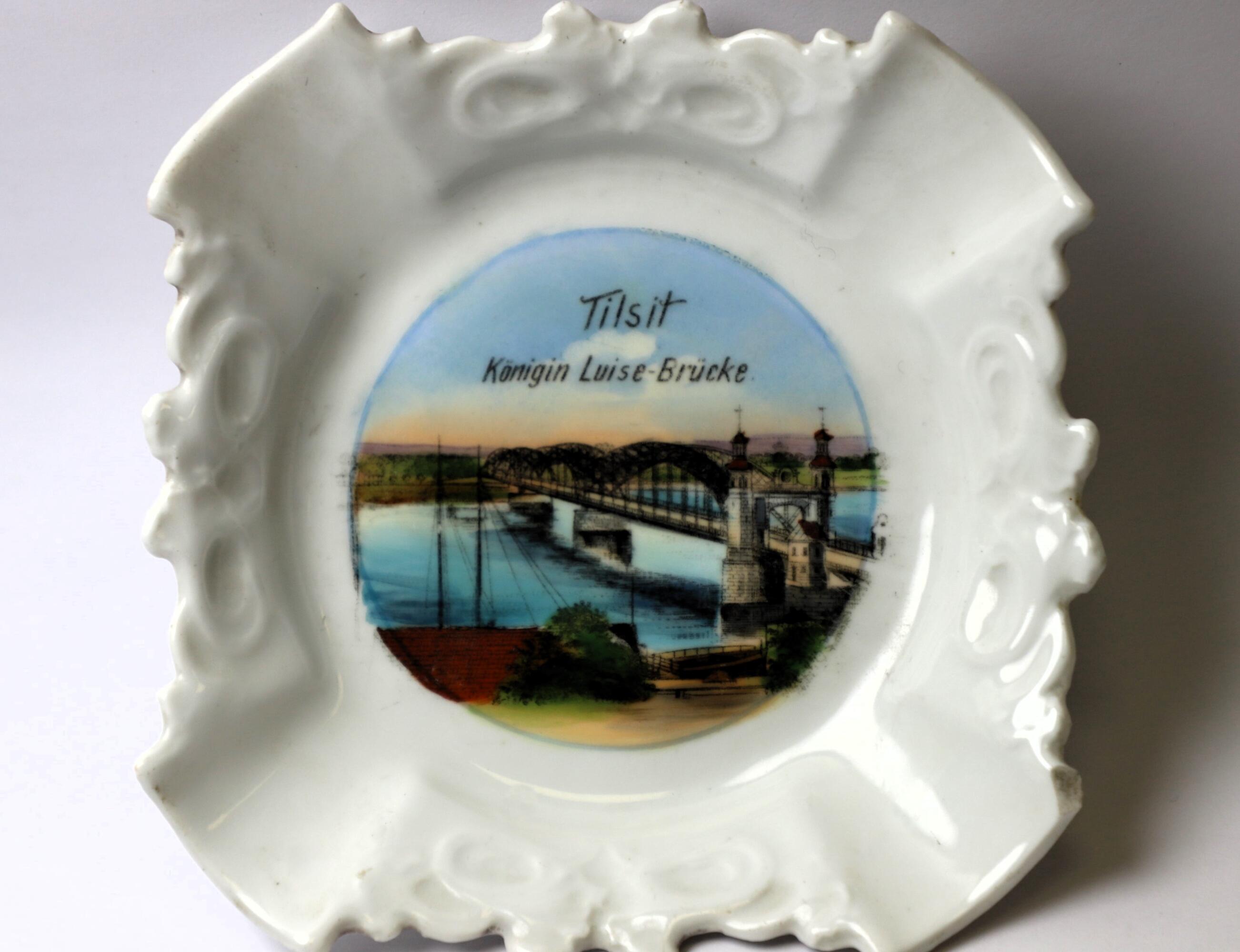 Porcelianinė peleninė su Nemuno vaizdu ir tiltu bei įrašu TILSIT. KONING LUISE-BRŪCKE. XX a. pr. įsigyta iš D. Aleknienės. 
