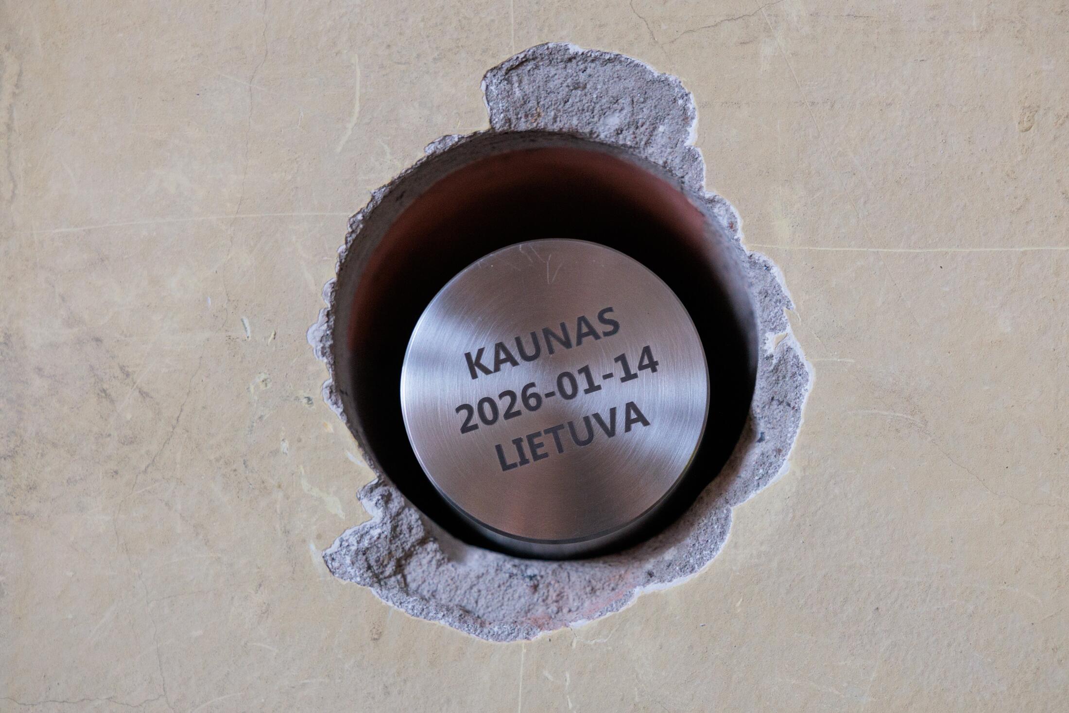 Simbolis: kapsulė su palinkėjimais – Kauno centrinio pašto atgimimo pradžios ženklas.