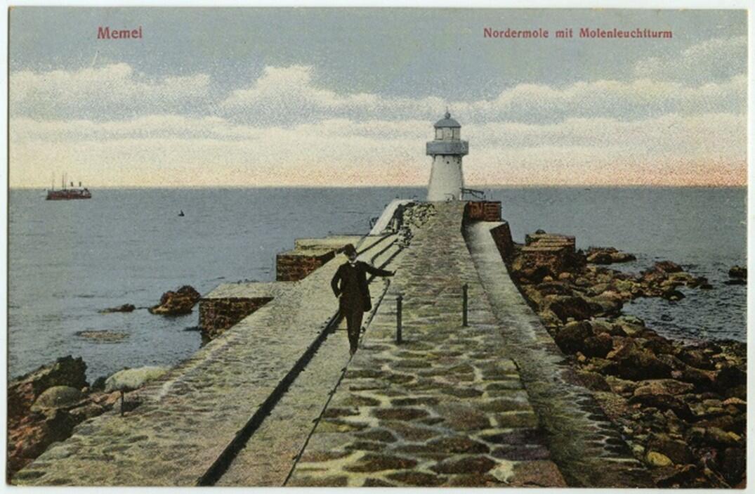 Vienišas vyras pozuoja prie Baltojo švyturio, XX a. 1-asis dešimtmetis. Johannesʾo Schenke’ės atvirukas.