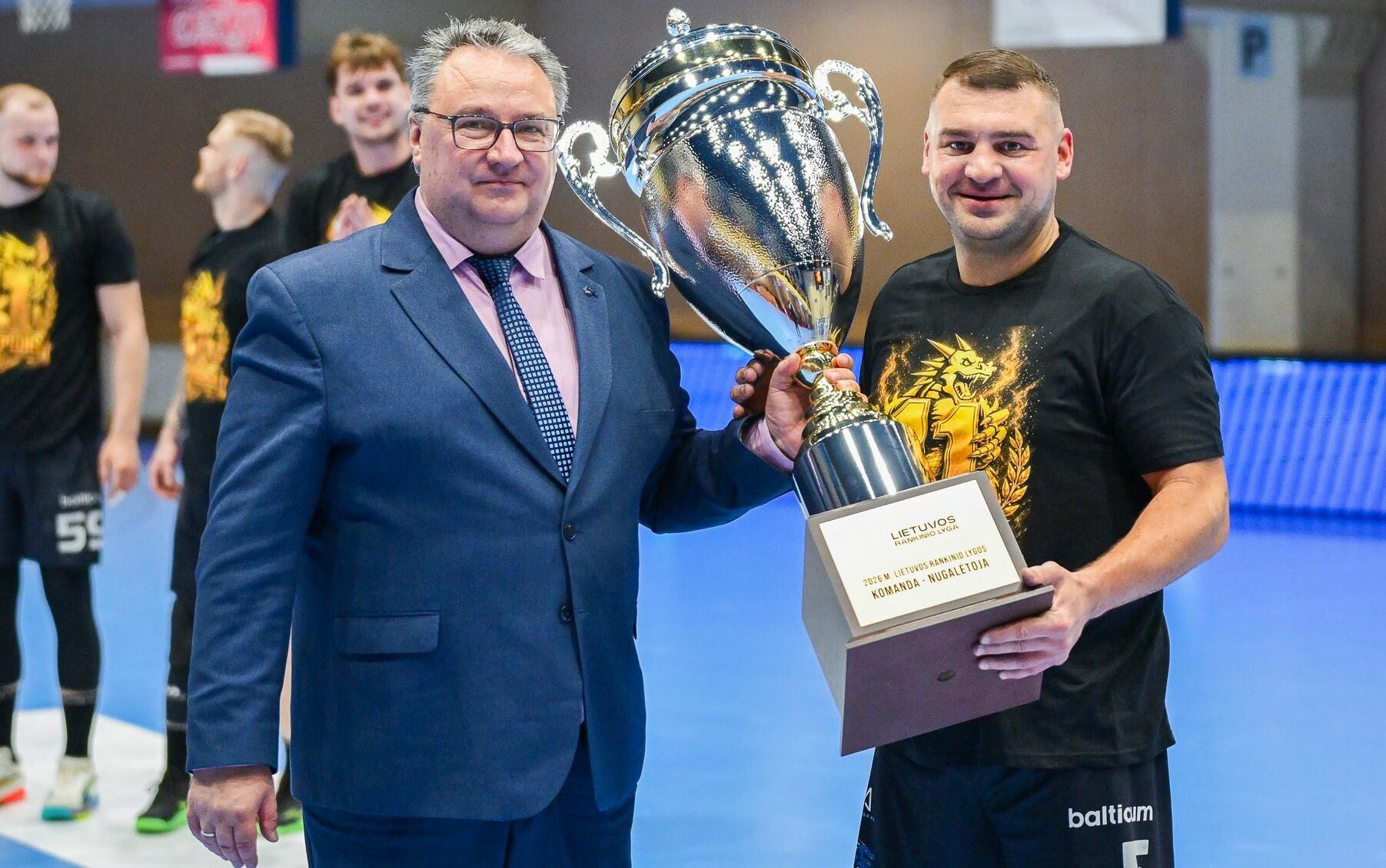 Pasveikino: „Dragūno“ kapitonui A. Bučiui (dešinėje), iškovojusiam 11-ąjį aukso medalį, čempionų taurę įteikė Rankinio lygos vadovas Tadas Jansonas (kairėje).