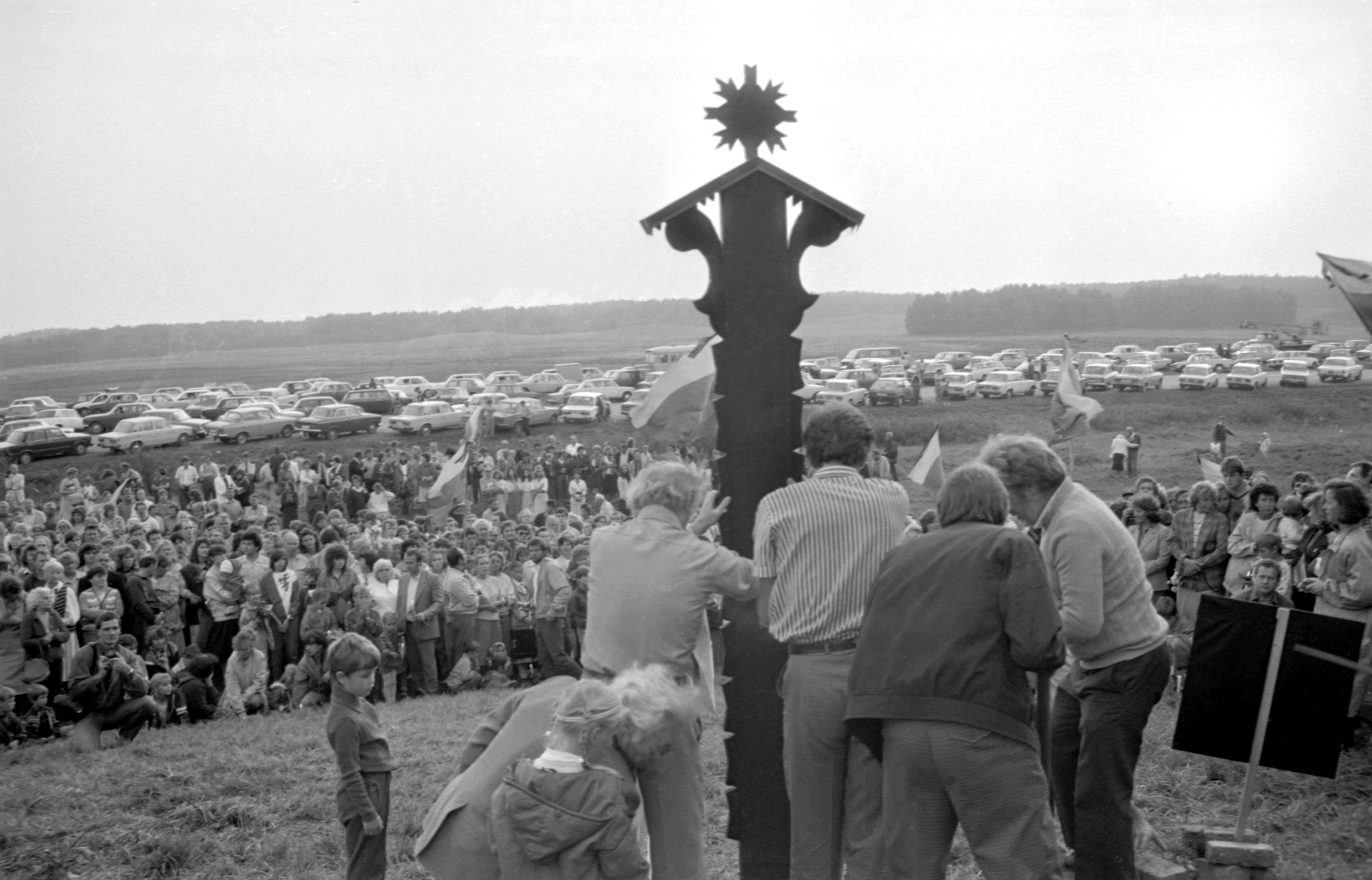 Baltijos kelio akcijos metu grupė žmonių stato koplytstulpį su datomis „1939–1989“. Kairėje stovi architektas Algimantas Nasvytis. 