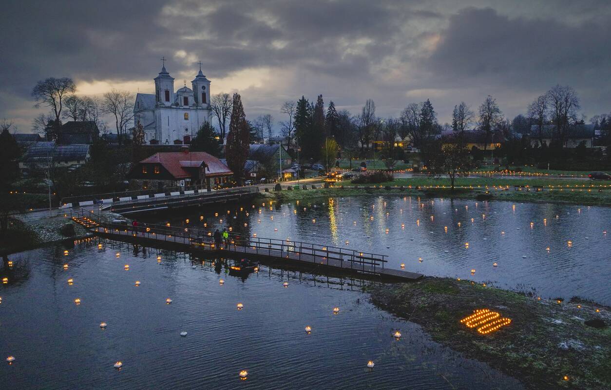 Akcentas: uždegtos žvakutės simbolizuoja ir žmonių vienybę, ir pagarbą V. Intui.