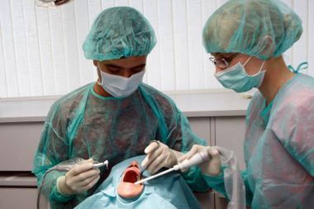 Operacija: tokie vaizdai odontologijos klinikose – įprasti, gydytojai savo pacientui išima siūlus  po pirmojo implantacijos etapo.