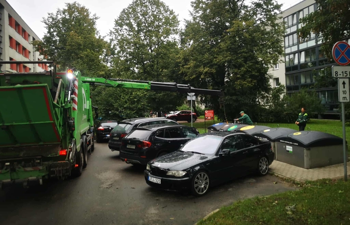 Ekvilibristika: atliekų vežėjams tenka šiukšlių konteinerius traukti automobilinės gervės pagalba.
