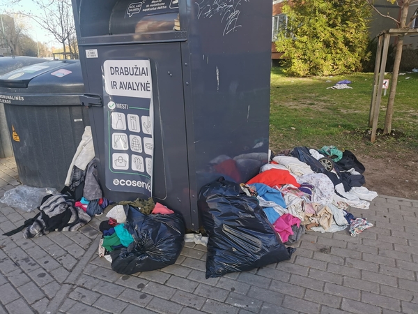 Netvarka: prie Ievos Simonaitytės gatvėje esančio tekstilės konteinerio mėtosi kalnai drabužių.