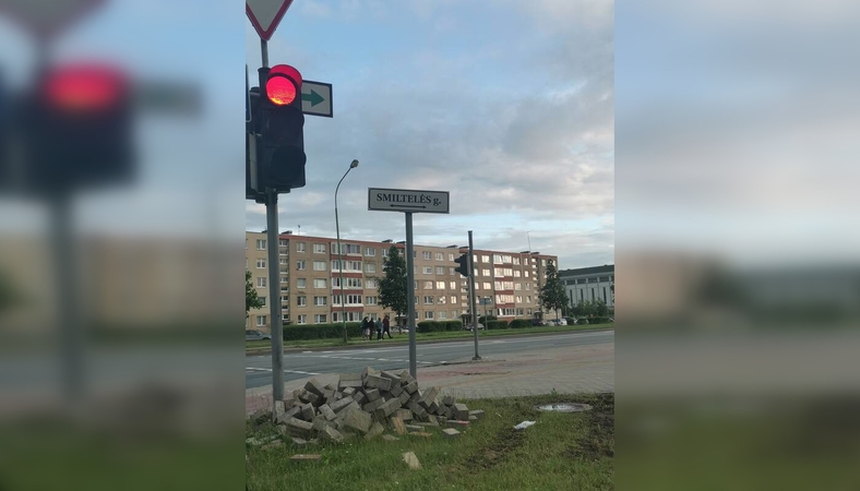 Netvarka: prie pėsčiųjų perėjos jau beveik mėnesį stūkso sukrautos trinkelės, kurios kelia nepatogumų praeiviams ir dviratininkams.