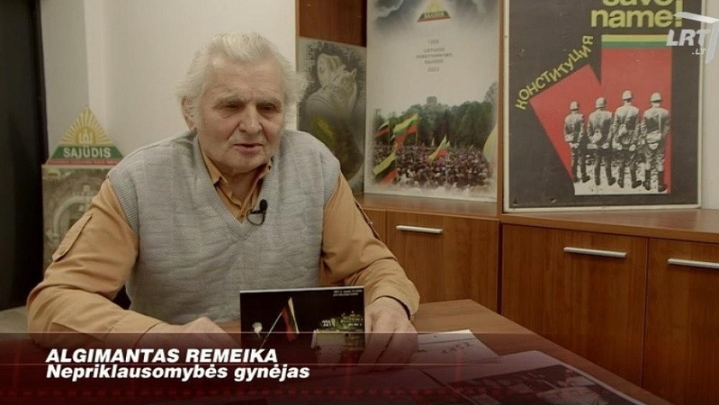 Žmogus, prieš tankus stojęs su vėliava rankose