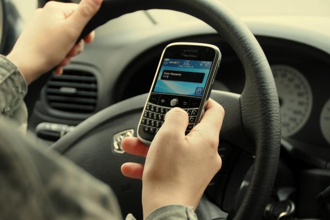 Italas vairavo kalbėdamas dviem telefonais