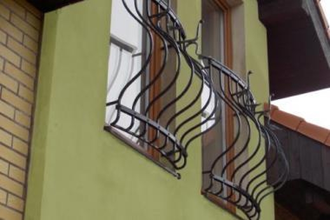 Kampas: tas pats balkonas iš šono atrodo jau kitaip – lanksčios metalo linijos vizualiai persidengia tinkleliu.