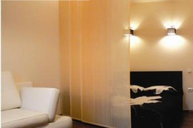 Sprendimas: dvigulę „miegamojo“ lovą skiria pusiau skaidrios slankios širmos.